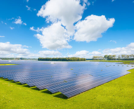 Aerial drone view of solar panels in a renewable energy farm. Sky with clouds. Sustainable green power station for clean electricity production and environmental technology infrastructure.