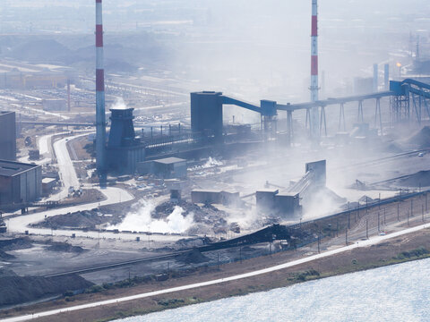 Aerial view. Heavy industrial steel plant with smoke emissions into the atmosphere. Metallurgical manufacturing process and environmental air pollution.