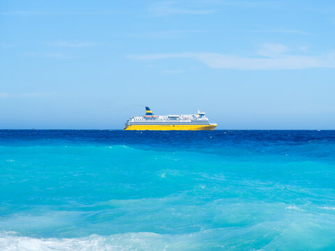 Ferry boat sailing on azure sea water with waves. Summer travel and transport trip during ocean vacation.