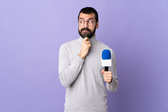 Adult reporter man with beard holding a microphone over isolated purple background having doubts and thinking