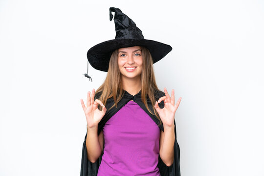 Young caucasian woman costume as witch isolated on white background showing an ok sign with fingers