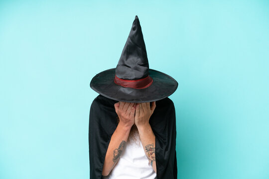 Young wizard in halloween isolated on blue background with tired and sick expression