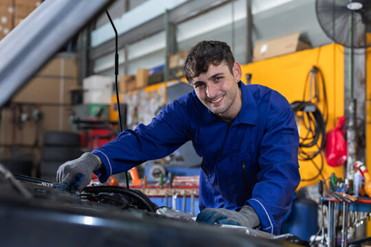 Mechanic repairs car engine in garage