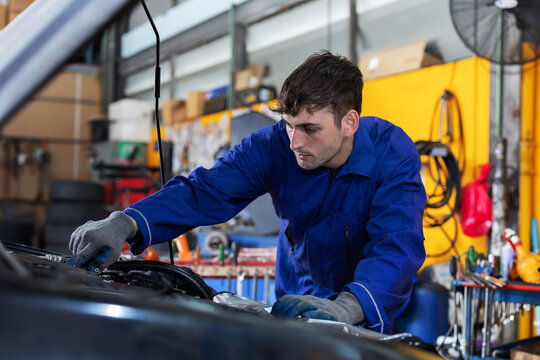 Mechanic repairs car engine in garage