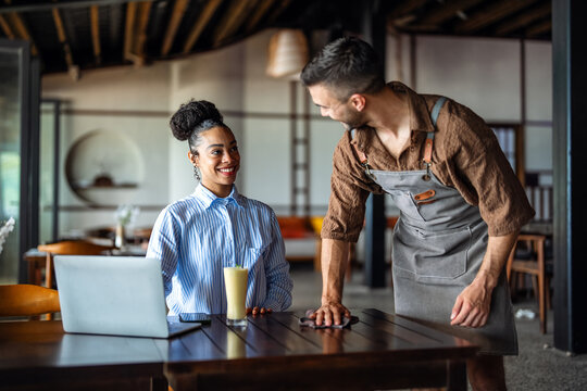 Pleased female customer receiving top quality food service at a modern restaurant