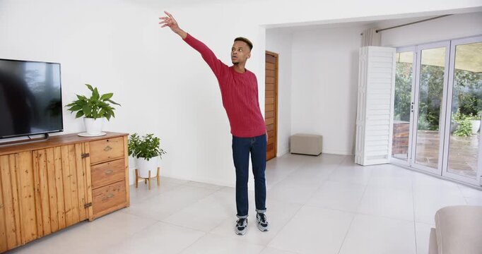 High speed photography for dynamic scenes, man in red sweater standing in living room, looking to si