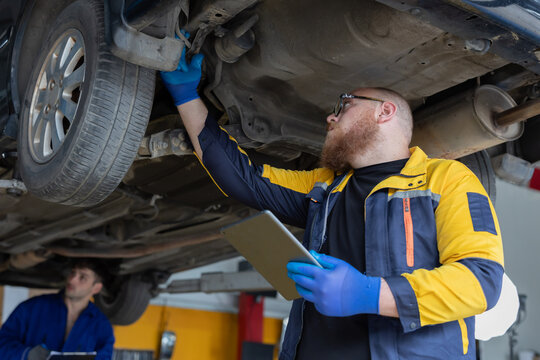 Mechanic repairs car engine in garage