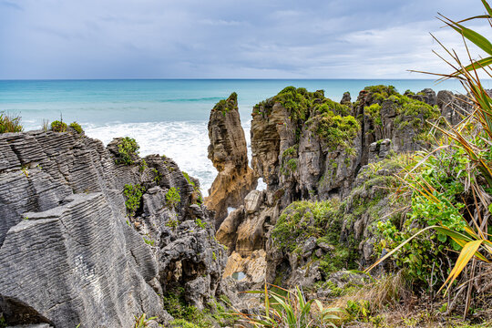 Enge Felsschlucht mit tosendem t&uuml;rkisem Wasser zwischen geschichteten Kalksteinw&auml;nden, Pancake Rocks, Punakaiki, Neuseeland