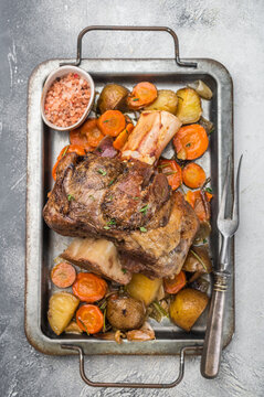 Italian veal osso buco shank braised with vegetables marrow bone and herbs on light stone background