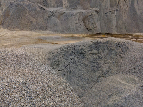 Aerial View of a Large Aggregate Stockpile with Distinctive Dune-Like Surface Textures at a Mining Site in Indonesia. Industrial Landscape and Abstract Geological Texture Viewed from Above.