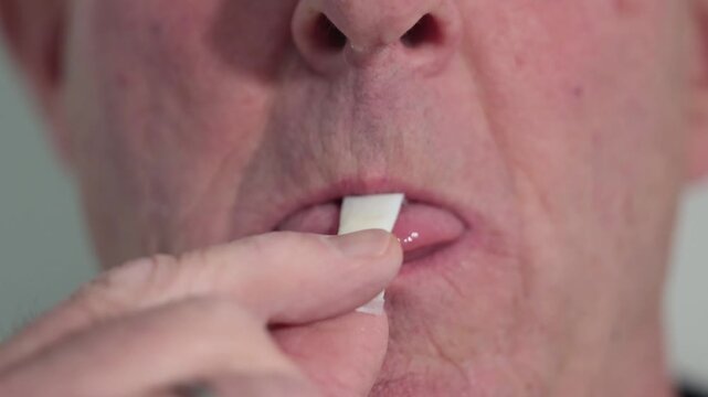 Stockholm, Sweden A man places a smokeless and tobacco-free nicotine pouch or snus on his tongue. 