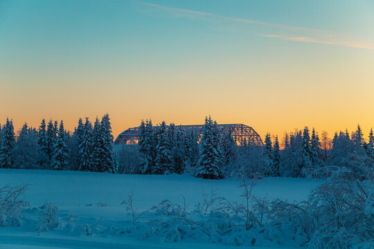 Sunset in a winter forest with snow-covered fir trees.