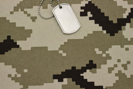 Blank silver military dog tag on digital camouflage pattern background