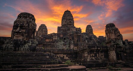 Obraz premium The iconic ancient stone faces of Bayon Temple during the breathtaking sunset in Siem Reap, Cambodia, provide a dramatic backdrop enhanced by ample, historical, sculpture and architecture concept