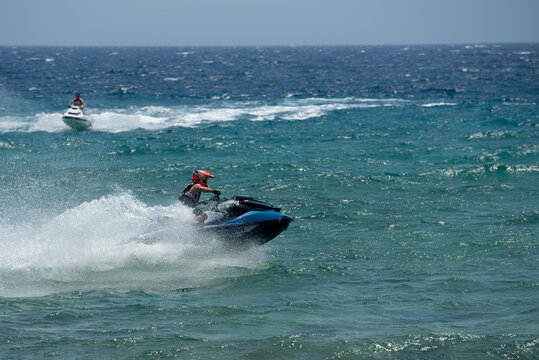 Jet skiing sport on rough waters with splashes and waves