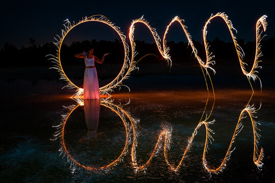 Woman posing for light painting photos Reflection in the water