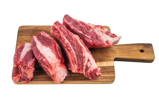 Raw beef short ribs cut into pieces on wooden board isolated on white background. Fresh meat portions for braising soup broth and BBQ.