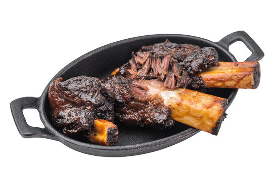 Braised beef ribs with pulled texture and caramelized surface in skillet. Slow cooked beef ribs with plate and back ribs appearance.