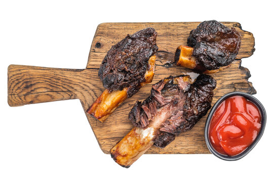 Juicy braised beef short ribs with shredded meat on wooden board. Slow cooked BBQ beef ribs plate and back style presentation.