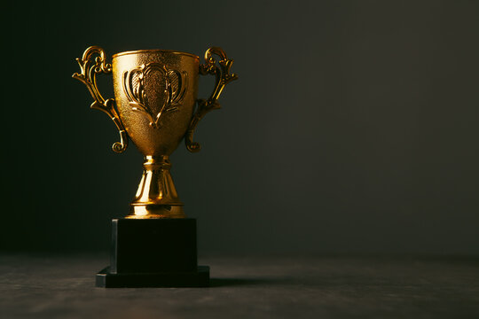 Golden trophy cup on dark background. Award concept.