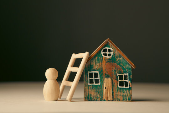 Mortgage concept. Wooden figure of a man and a ladder.