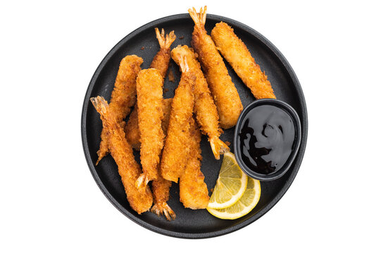 Panko fried prawns or ebi fry arranged on plate with sauce bowl and citrus wedges, crunchy deep fried seafood snack shot from above with copy space.