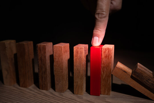 insurance with hands protect domino. Businessman hands stop dominoes falling in business crisis. business risk control and planning and strategies to run prevent insurance businesses.