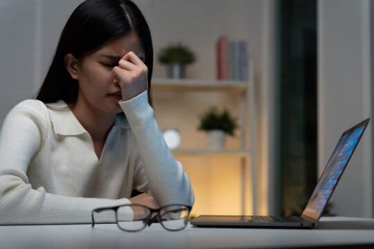 Eye problems, Asian women with tired and irritated eyes, eye rubbing, dry, eye pain after work, migraine, headache, blurred vision, photophobia, working in the dark, blue light from compute