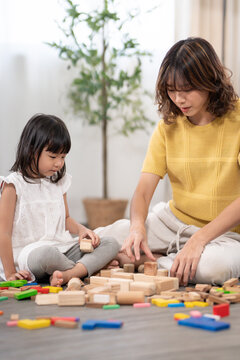 Happy Asia mother play and learn toy blocks with the little girl. Funny family is happy and excited in the house. Mother and daughter having fun spending time together. Holiday, Activity, development