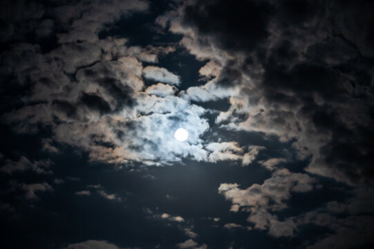 Bright moonlight breaking through dramatic clouds in the dark night sky, full moon and clouds in the sky over 27798 Hude, Oldenburg County, Lower Saxony, Germany