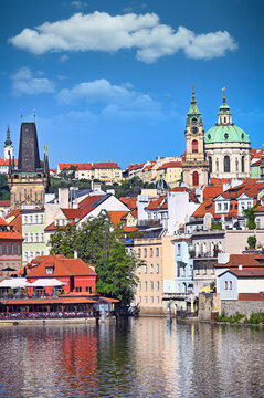 Scenic Vltava Riverfront with St. Nicholas Church and Lesser Town Bridge Tower in Prague