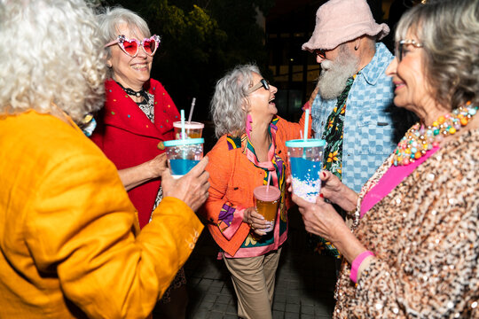 Group of happy senior friends with fancy clothing having party in the night