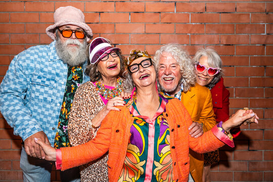 Group of happy senior friends with fancy clothing having party in the night