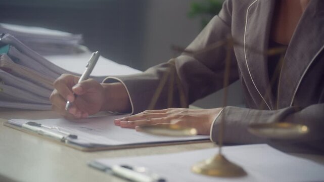 Legal Professional Reviewing and Signing Documents with Scales of Justice