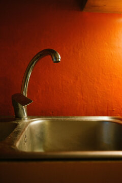 Old sink in front of an orange wall