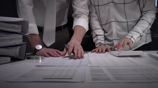 Business professionals analyzing financial documents. Calculating expenses. And reviewing data during a detailed tax audit or accounting investigation