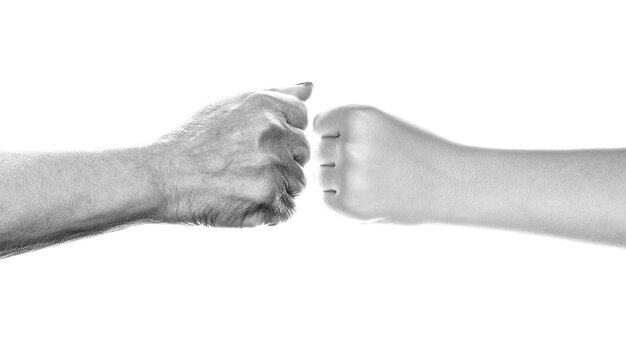 Giving a fist bump. Old man and kid holding hands are fist bumping. Little and big fists of father and son. Black and white