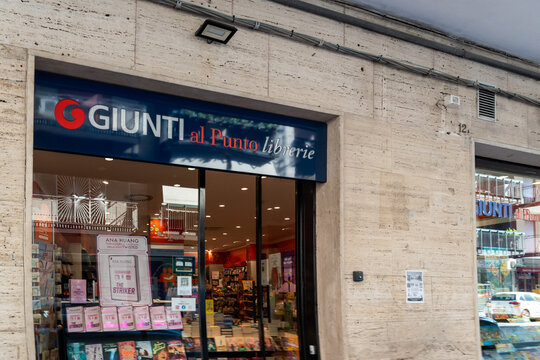 Barletta, Italy - Aug 1, 2026: Giunti al Punto bookstore shopfront with a blue illuminated sign and window displays of books and gifts set in a travertine building