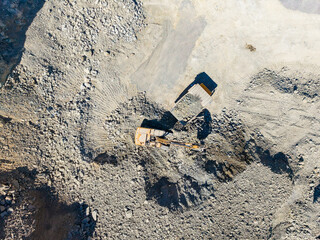 Granite quarry operation in progress with an excavator and dump truck at work © DSMT