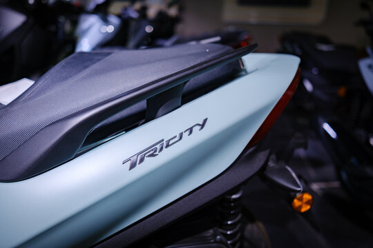 Tricity badge on the pale green flank of a Yamaha Tricity scooter