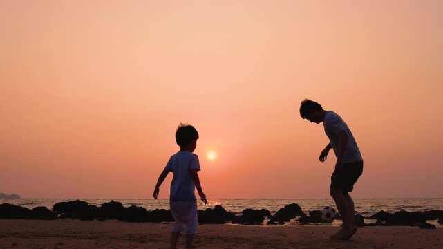 Silhouette of father and little son playing soccer together on sandy beach at sunset, happy family bonding activity, summer vacation, outdoor sport, ocean coast, and parenting love concept