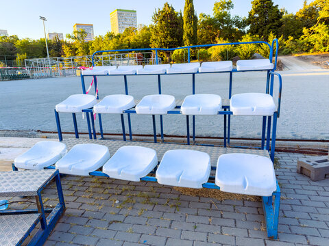 White seats in a sports venue waiting for spectators at sunset in a city park