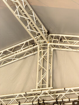 Metal truss structure inside a large tent for an event setup in a public space
