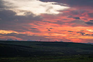 Fototapeta premium Vibrant clouds painting sky during sunset over landscape