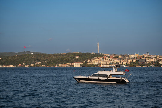 Istanbul,turkey,august 4, 2025. Luxury yacht cruising the bosphorus in istanbul with skyline and camlica tower under a clear blue sky, scenic waterfront view