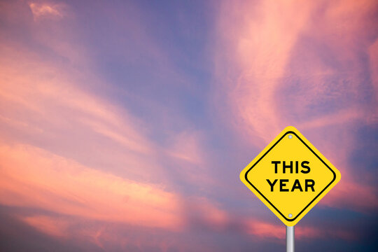 Yellow transportation sign with word this year on violet color sky background
