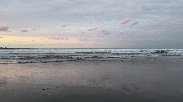 Static ground-level view of ocean waves washing onto a sandy beach, capturing the natural rhythm of the shoreline and a peaceful coastal atmosphere.