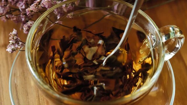 Hot tea in a clear glass cup on a wooden table	
