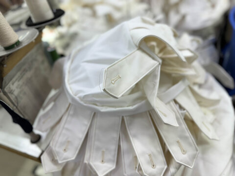 Avant-garde white sculptural garment with pleated collar and cascading fabric details