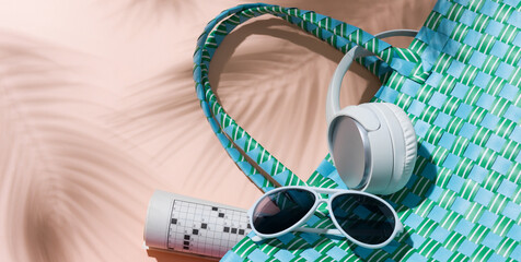 Obraz premium Turquoise Beach Bag with Headphones, Sunglasses and Crossword Puzzle